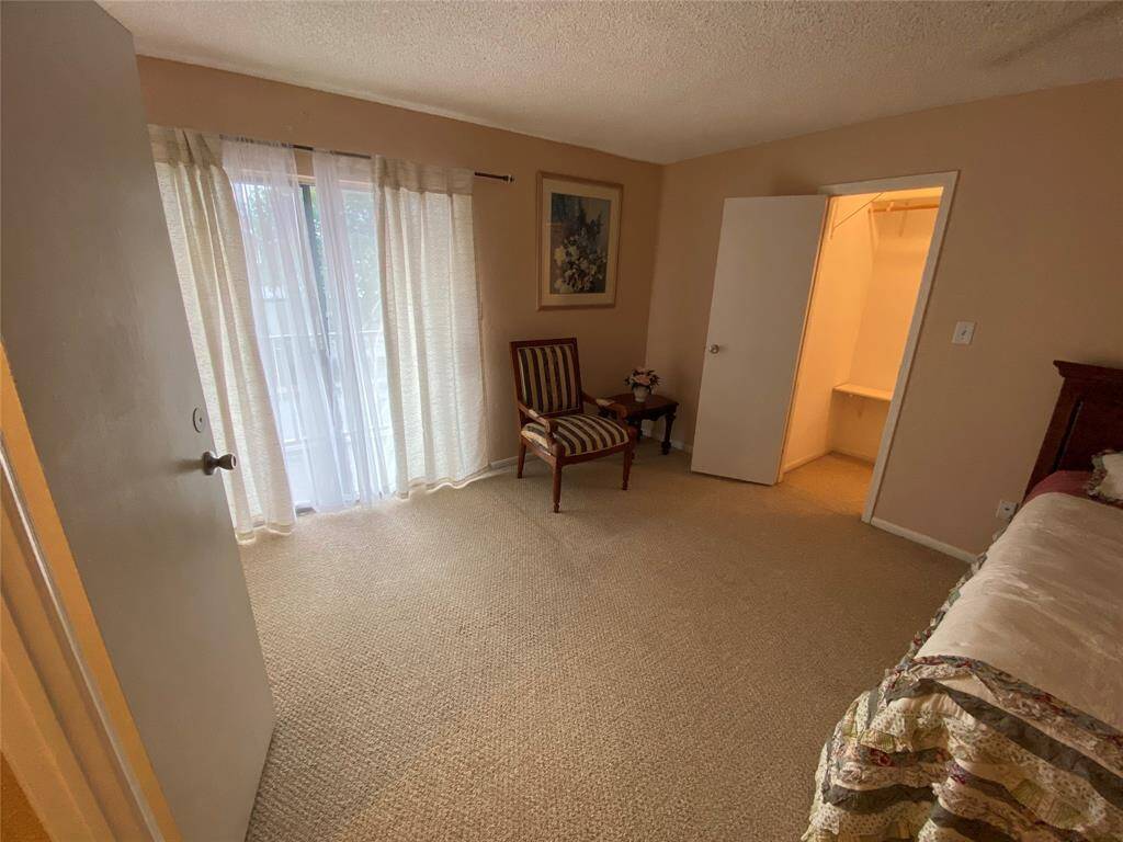 This bedroom features carpet flooring, a sliding glass door opens up to private balcony