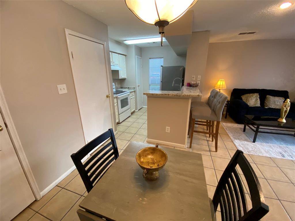This home features an open-concept living area a compact kitchen with white cabinetry. The dining area flows into a comfortable living room creating a welcoming atmosphere.