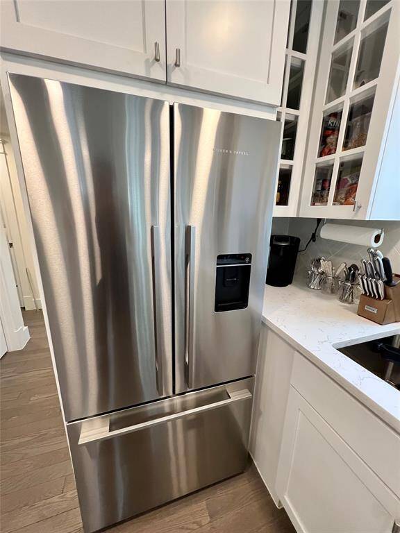 The kitchen features a sleek stainless steel oven and microwave, complemented by a wine rack, under-cabinet lighting, and a chic herringbone backsplash.