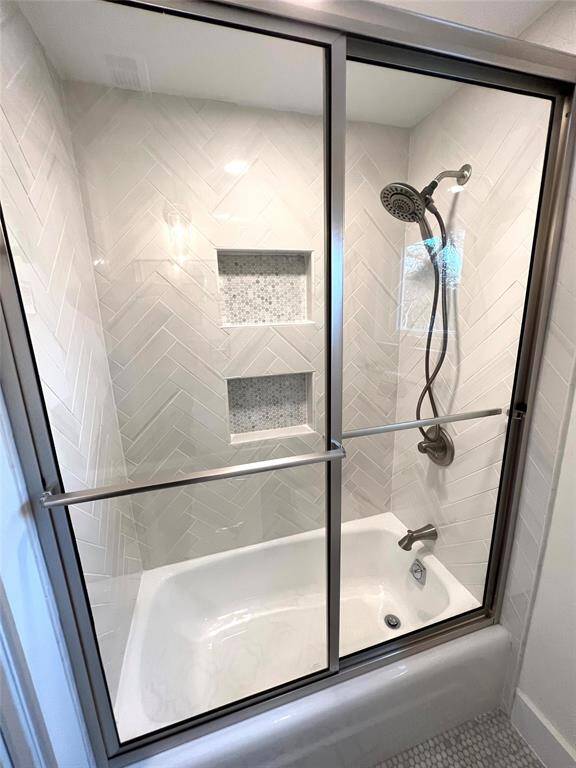 Elegant hall bathroom with a stylish tub and shower combo.