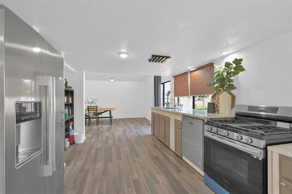 This spacious kitchen features modern stainless steel appliances and a bright dining area with natural light. The open layout is perfect for entertaining and everyday living.