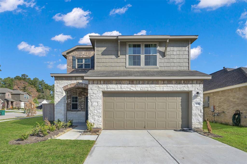 This is a two-story home featuring a stone and siding exterior, with a single-car garage. The lawn is neatly landscaped, and sits on a nice corner lot.