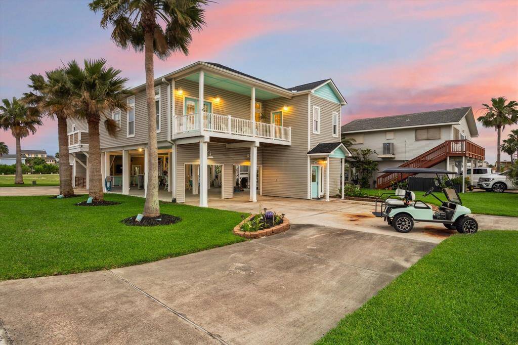 circular driveway is accompanied by lush landscaping