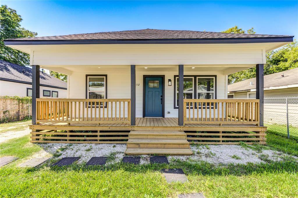 Charming single-story home with a welcoming front porch, featuring a modern blue door. The exterior is clean and well-maintained, set against a backdrop of greenery and neighboring homes.
