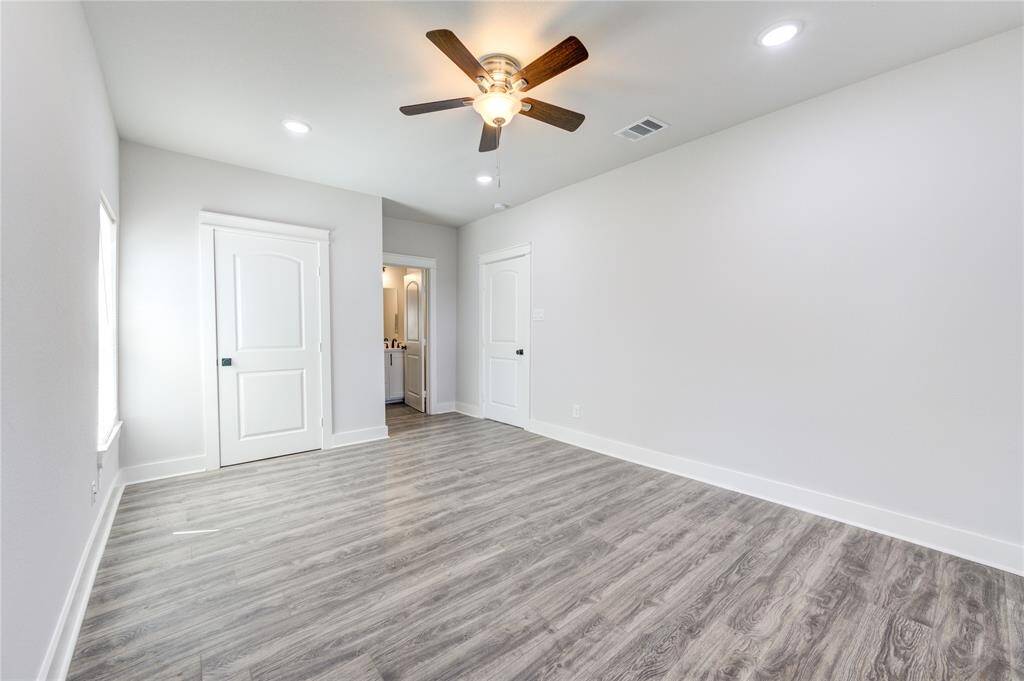 Spacious primary bedroom featuring elegant flooring, ample natural light, and a convenient en-suite bathroom.
