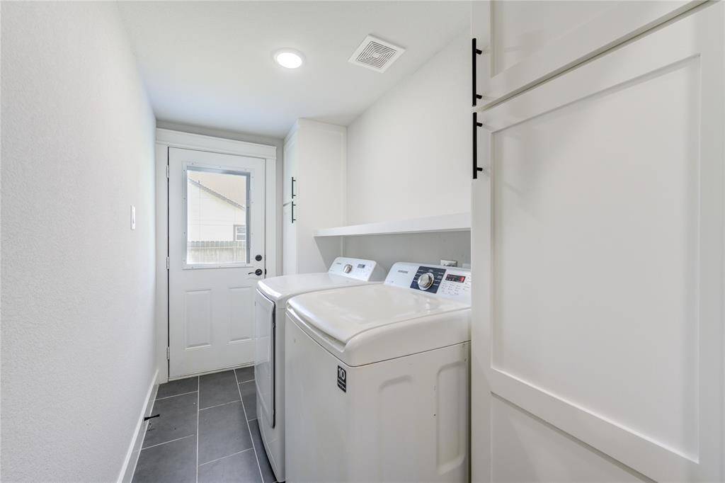 Efficient laundry room featuring modern appliances, ample storage, and a convenient exterior door.