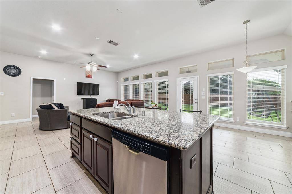 Opposite view from the kitchen reveals the spacious living room and rear of the home, showcasing a wall of windows that floods the space with natural light.