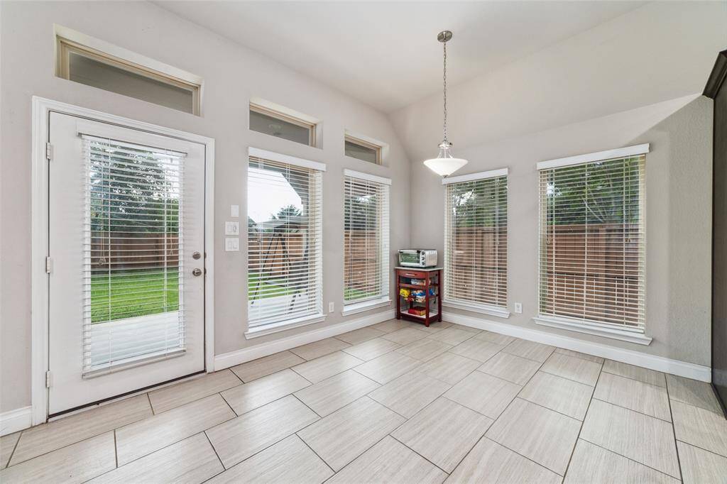 Charming breakfast nook surrounded by a wall of windows, offering abundant natural light and a lovely view to start your day.