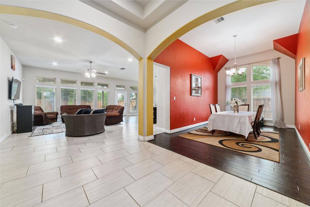Open-concept floor plan showcasing a formal dining room with elegant engineered wood flooring.   NOTE: Painting concession may be considered, allowing you to add your own personal touch