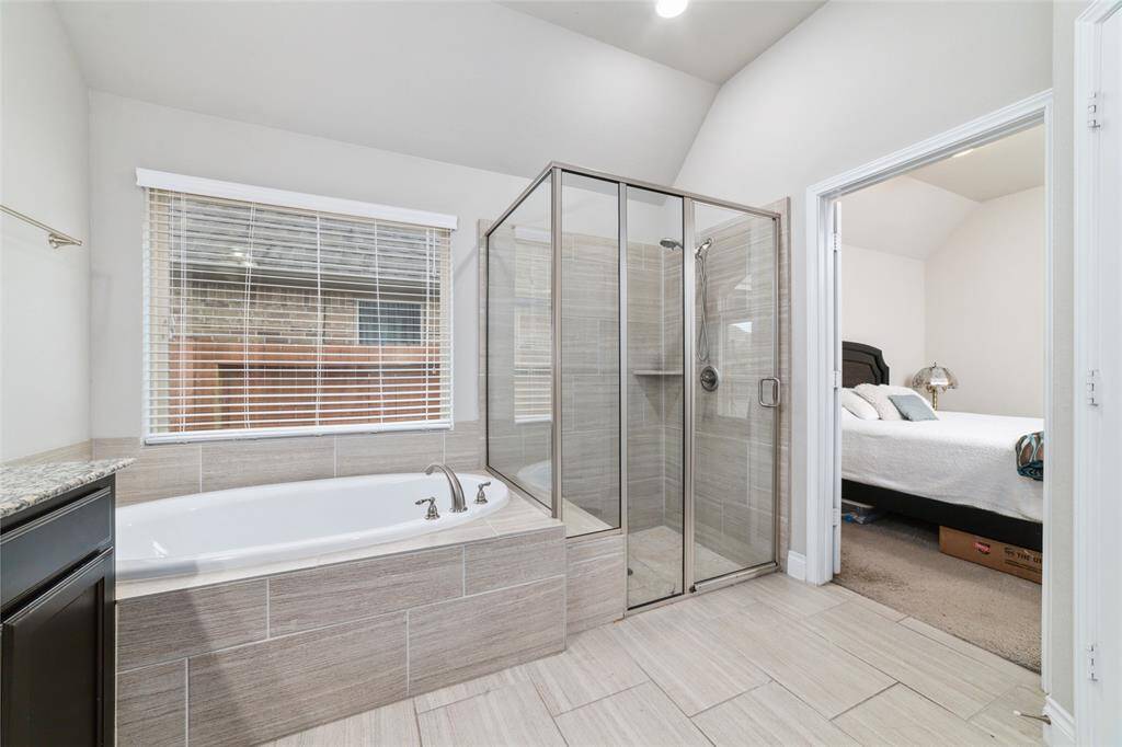 Primary bathroom suite with a spacious walk-in shower featuring a built-in bench and neutral, timeless tile finishes