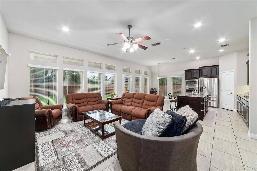 Reverse view of the living room highlighting the open-concept layout, with a clear line of sight to the breakfast area and kitchen, plus a stunning wall of windows that fills the space with natural light.