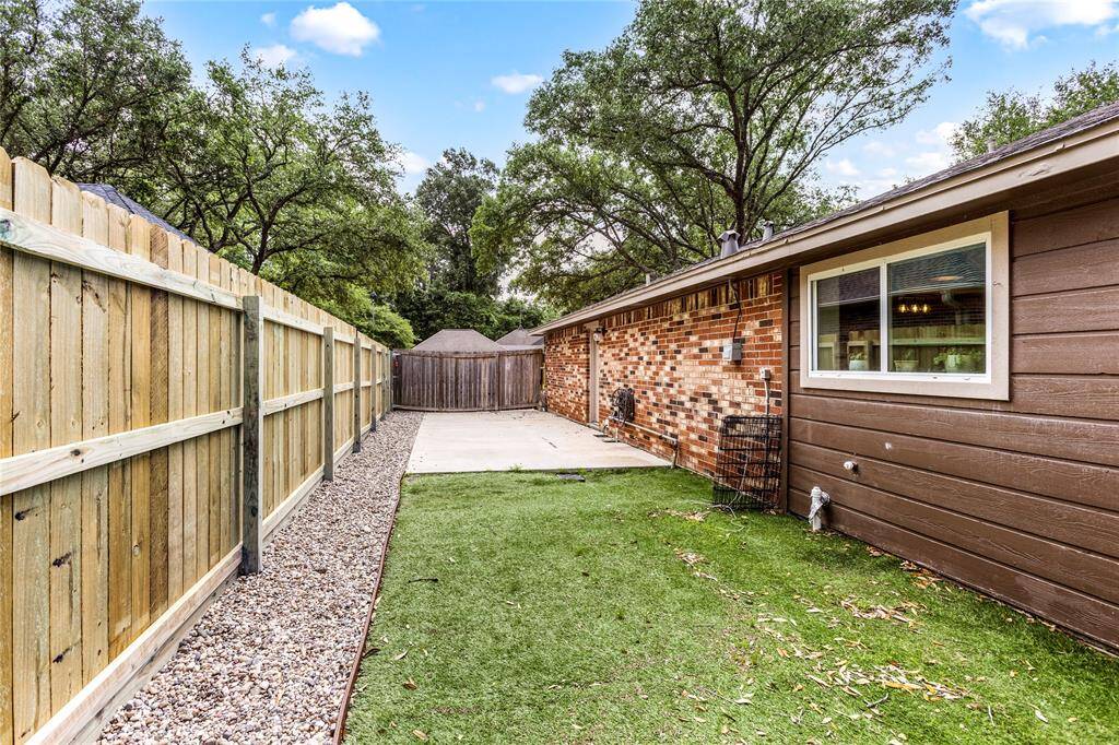 Side yard with new fence and bullrock.
