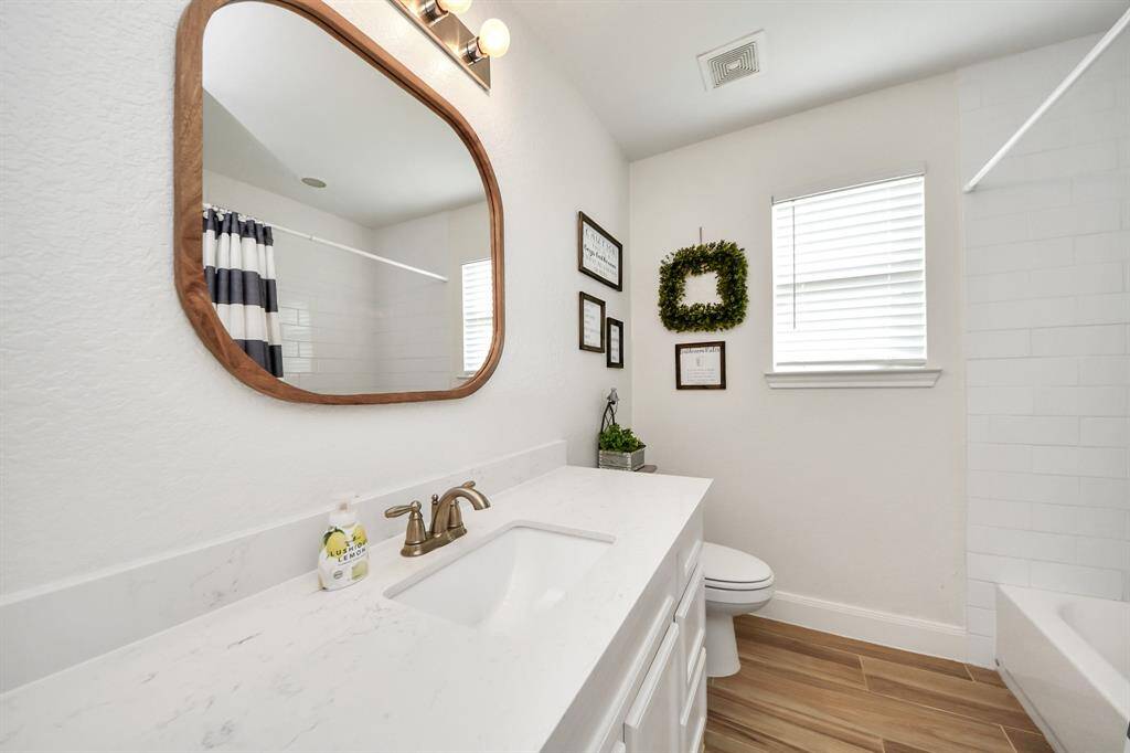 Secondary bathroom with custom mirror and updated counters and tile!