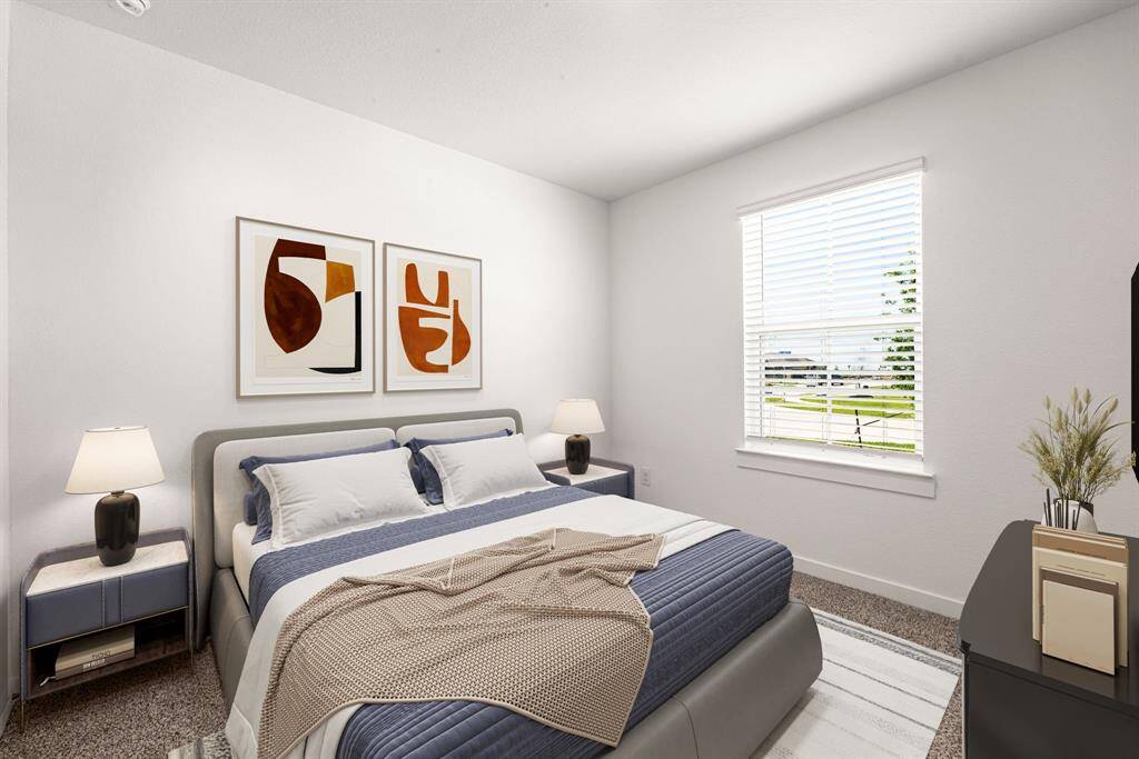 This bright and inviting bedroom features soft, neutral tones and a large window that fills the space with natural light. The room offers a spacious layout with plush carpeting and clean, modern finishes, making it a comfortable and relaxing retreat.