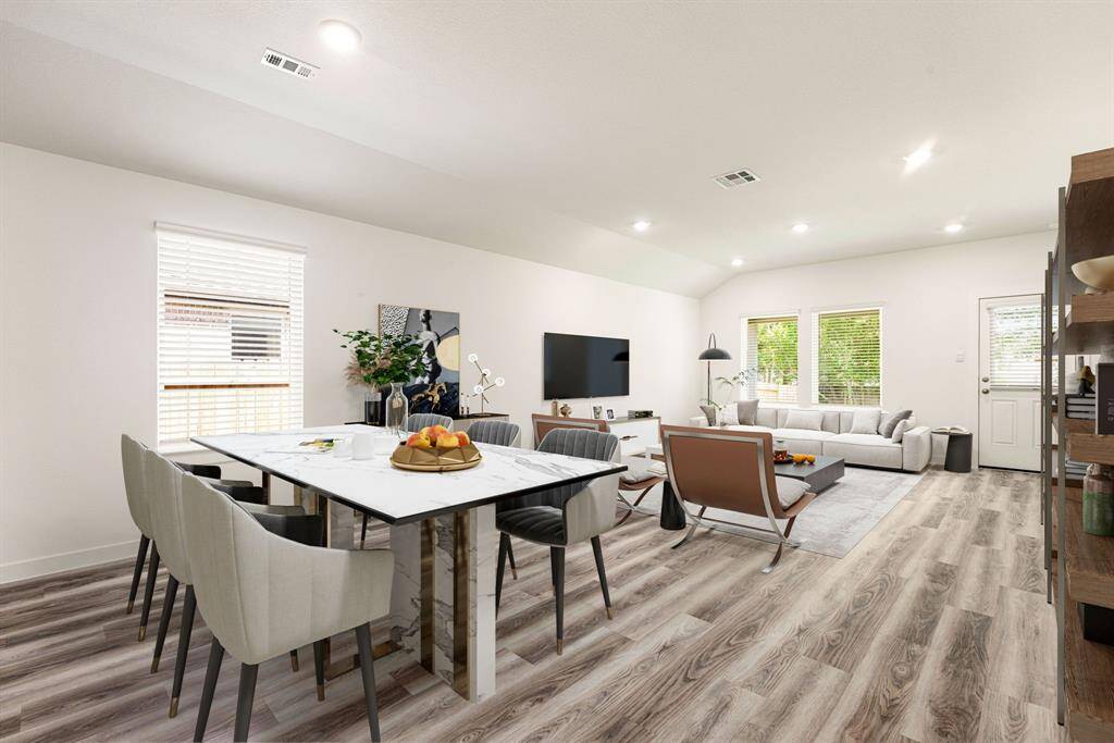 This bright and open-concept living and dining space is enhanced by expansive windows that flood the room with natural light, highlighting the elegant wood-look flooring throughout. The high ceilings and recessed lighting create a spacious, airy atmosphere, while neutral tones provide a timeless canvas ready for your personal touch. Perfect for both everyday living and entertaining.
