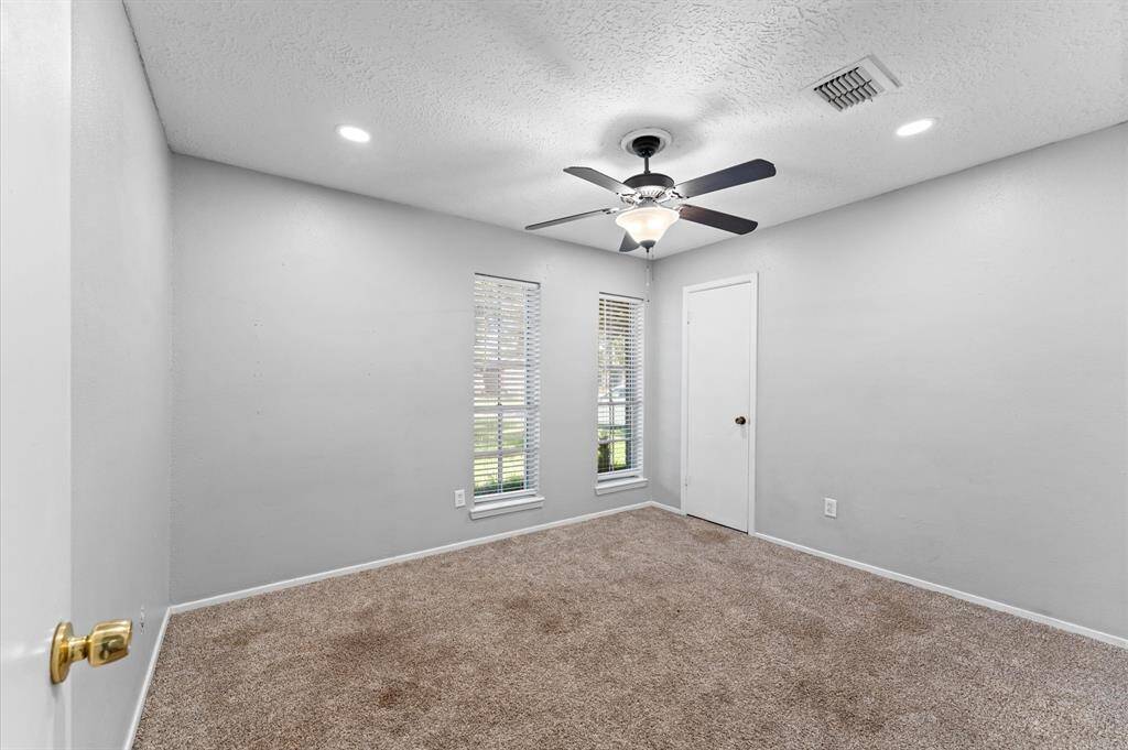 Bedroom 1 offers recessed lighting, plush carpet and a walk-in closet.