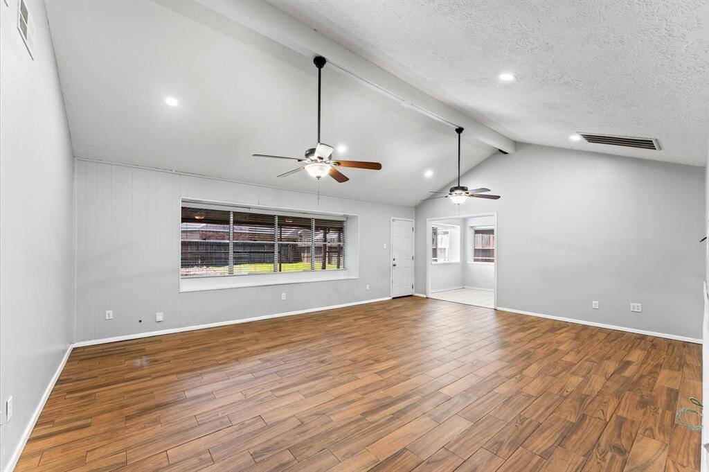 The primary suite features tile plank flooring, recessed lighting, and walk-in closet.