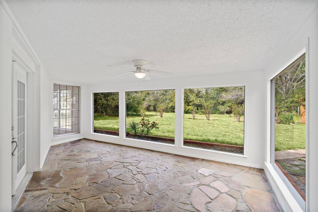 Large third living area featuring a a gorgeous hand laid field stone floor. Walls of windows provides panoramic views of the beautiful back acreage.