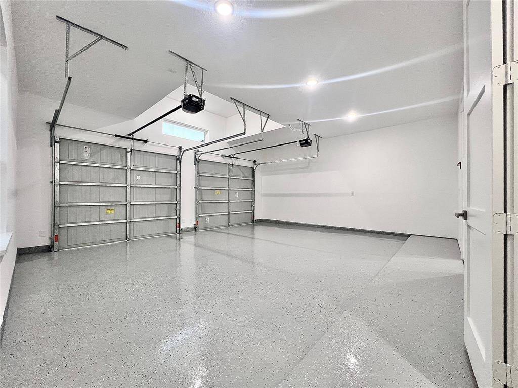 Large 24'X 22 Epoxy Garage Floors with 10' Ft. Ceiling Height, 3 white light LED can lights, Garage Door Openers and Tandem Window above Garage Doors, give this Garage a Gym-like feel.
