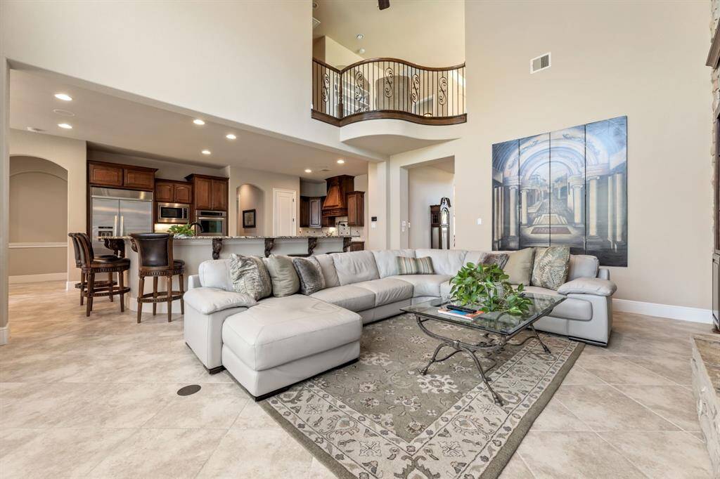 A grand, open-concept living space with soaring ceilings and a seamless connection to the upstairs landing. The design allows natural light to flood in, creating an airy and inviting atmosphere.