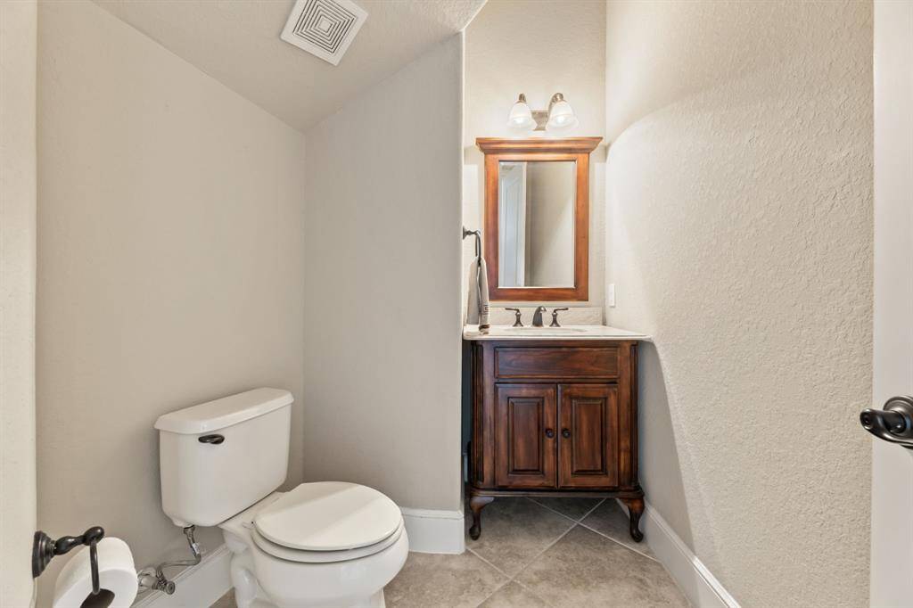This powder room exudes old-world charm, with a striking vanity that blends classic design with a touch of medieval influence.