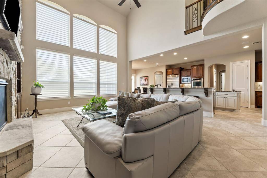 Flooded with natural light from two levels of oversized windows, this spacious living area feels bright, airy, and effortlessly sophisticated.