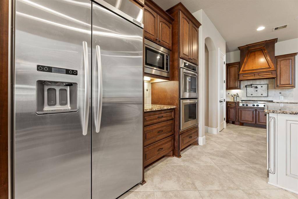Thoughtfully designed, the kitchen offers ample storage and a functional layout, with maple and alder wood cabinetry enhancing its beauty.