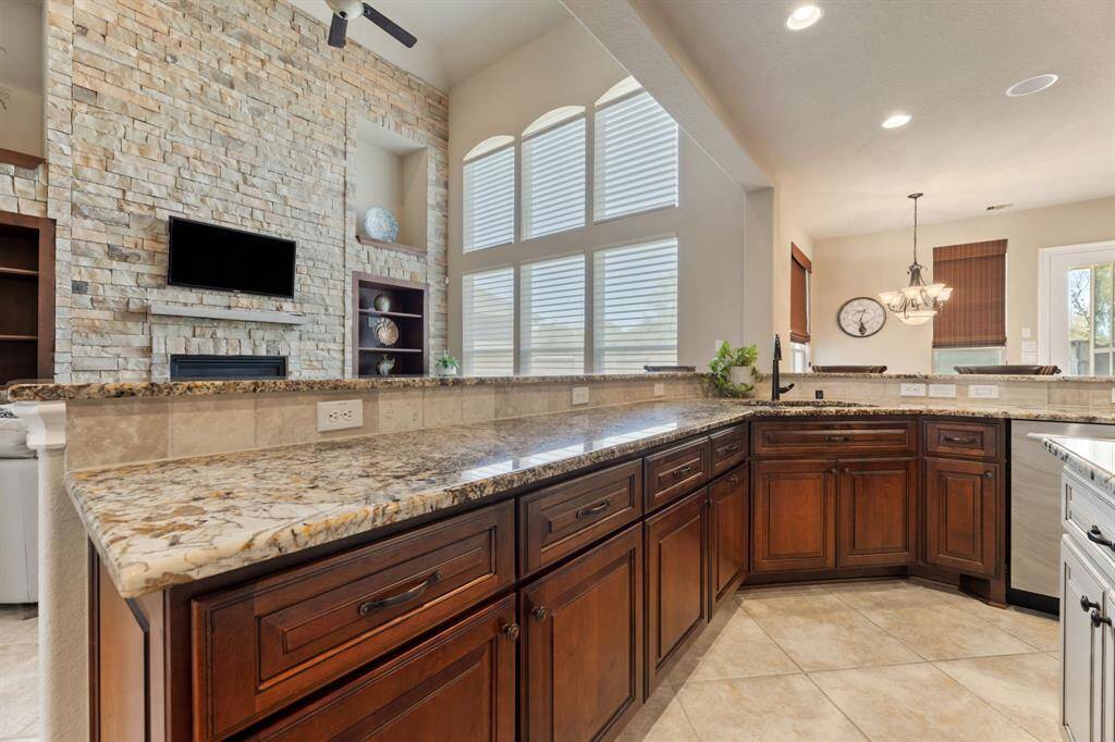 This perspective showcases the expansive granite countertops, custom cabinetry, and seamless flow into the living room.