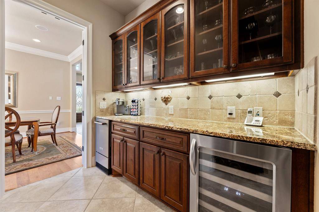 Elegant glass-paneled upper cabinets offer display space, with under-cabinet lighting casting a soft glow onto the countertop.
