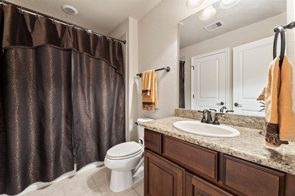 Another full bathroom with a harmonious blend of warmth and elegance, featuring a vanity that echoes the home’s signature design elements.