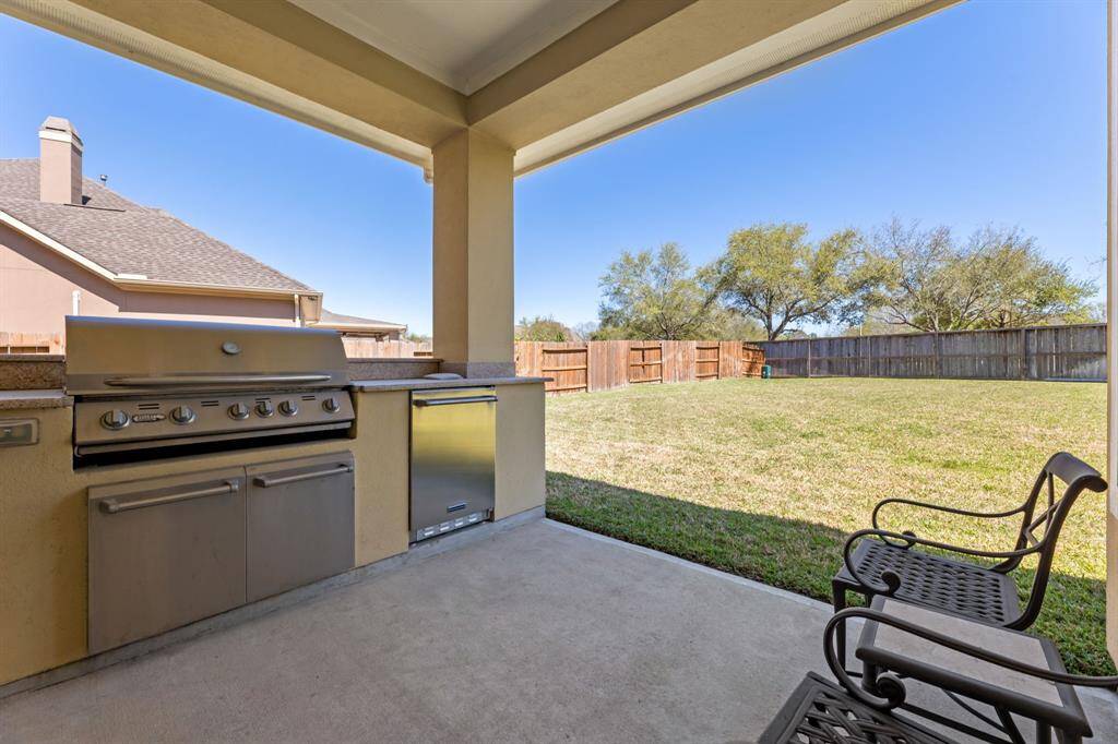 The patio is a shaded retreat overlooking the backyard, providing plenty of space for outdoor relaxation.