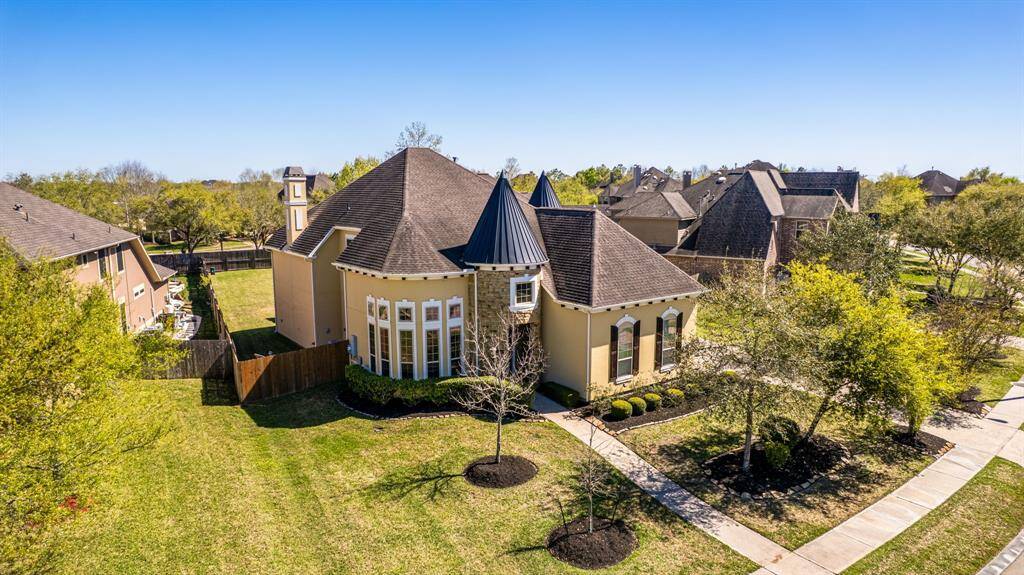 A sweeping view highlights the home’s impressive architecture, expansive front lawn, and meticulously maintained landscaping.