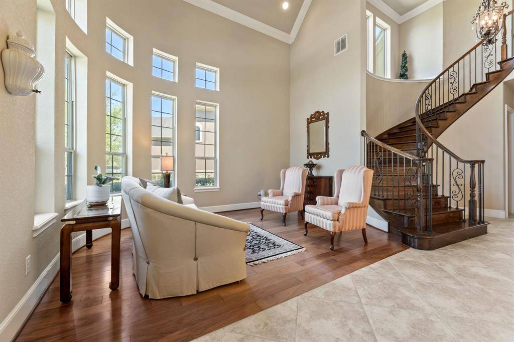 The high ceilings and gracefully ascending staircase create a sense of openness, while the foyer offers a refined space for relaxation or conversation.