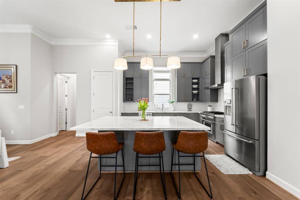 Experience culinary luxury in a gourmet kitchen with an expansive island, elegant Carrera marble countertops, and abundant storage.