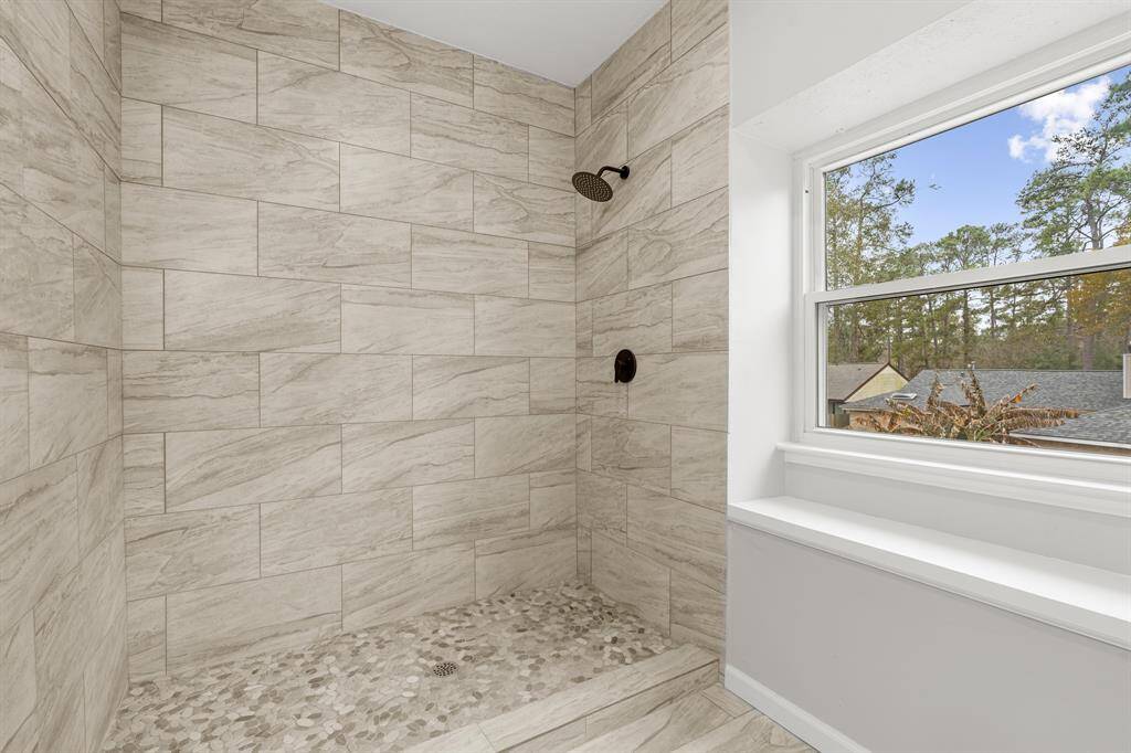 It is complete with a beautiful  walk-in shower with gorgeous tiling, and a large window providing natural light.