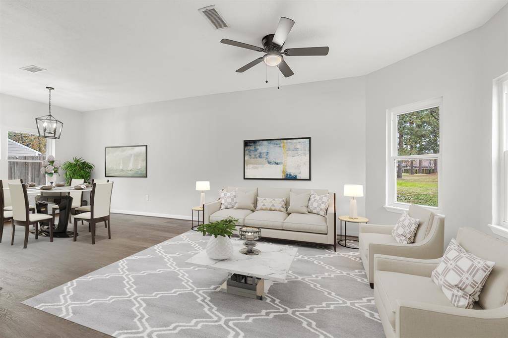 Virtually Staged: This inviting and bright living room features a high ceiling, a dark wood stained ceiling fan, beautiful vinyl plank floors, and large windows allowing natural light!