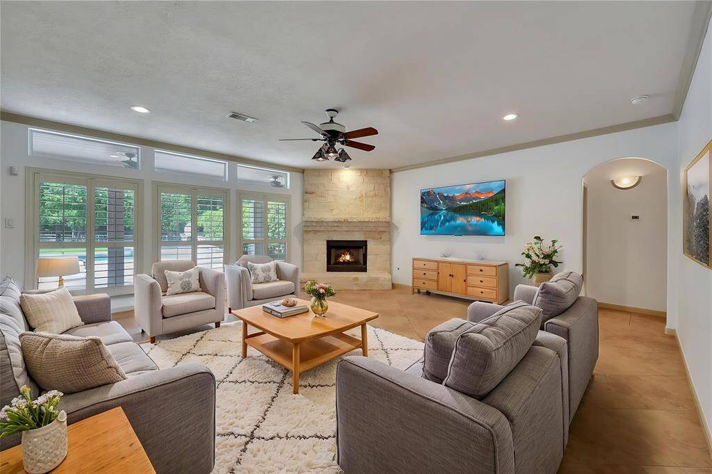 *virtually staged* Living room flooded with natural light has gas stone fireplace