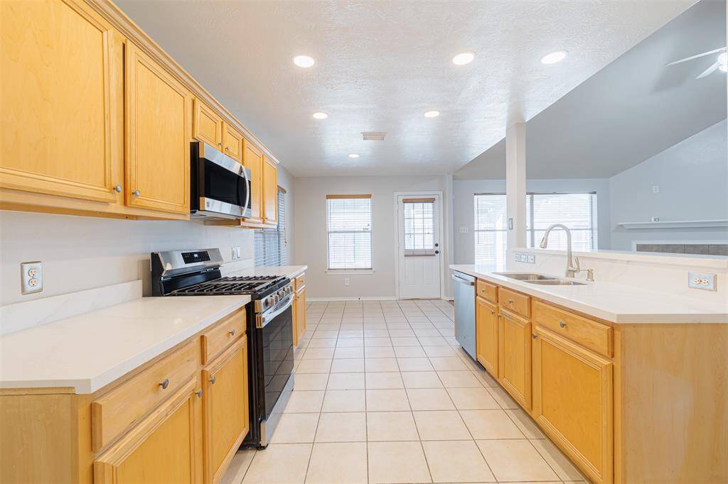 Beautiful kitchen with new appliances and recessed lighting.