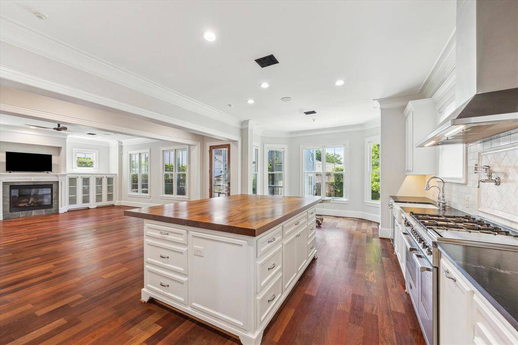 Expansive Gourmet Kitchen: Bathed in natural light, this chef’s kitchen features a grand central island with rich wood countertops, sleek stainless steel appliances, and custom cabinetry. Perfectly designed for culinary creations and seamless entertaining, all set against a backdrop of floor-to-ceiling windows.