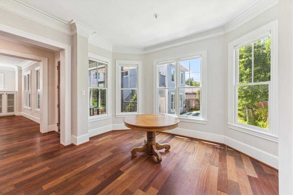 Sunlit Breakfast Nook: This charming dining space is surrounded by panoramic windows, bathing the area in natural light and offering serene views. Perfect for cozy mornings or intimate dinners, set against the warmth of rich hardwood floors.