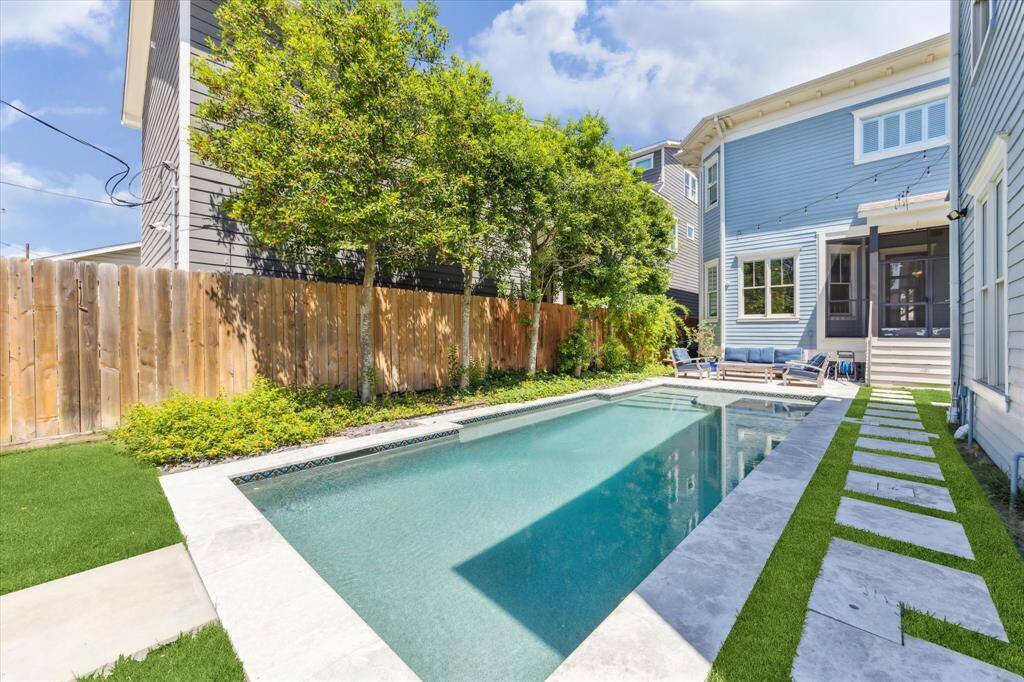 Sleek Poolside Retreat: This stunning backyard features a modern lap pool with a sleek stone walkway and lush privacy landscaping. Perfect for relaxing, entertaining, or enjoying a refreshing swim, this outdoor space offers a serene escape in the heart of the city.