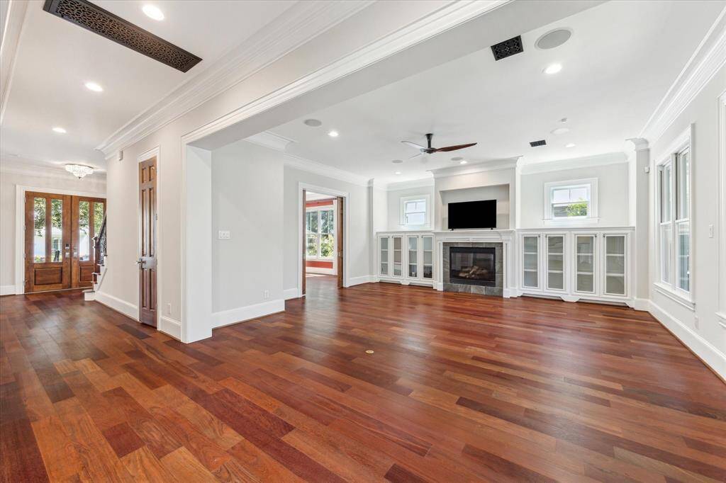 Expansive Gathering Space: This stunning living area features rich hardwood floors, a cozy fireplace framed by built-in cabinetry, and abundant natural light. Perfect for both intimate evenings and grand entertaining, this room seamlessly blends comfort and elegance.