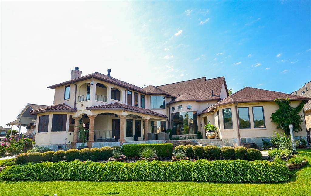 This home was thoughtfully designed with the view in mind. This view from your boat dock reveals the summer kitchen and outdoor family room on the left, with the second primary suite downstairs to the right. The entire upper level boost the primary suite, sitting room, upstairs living area and office, with the pool and spa commanding the spotlight in this enchanting tableau.Moreover, the complete upper area frames a breathtaking view of the lake and the sunset. Adjacent to the upstairs patio, you'll fin