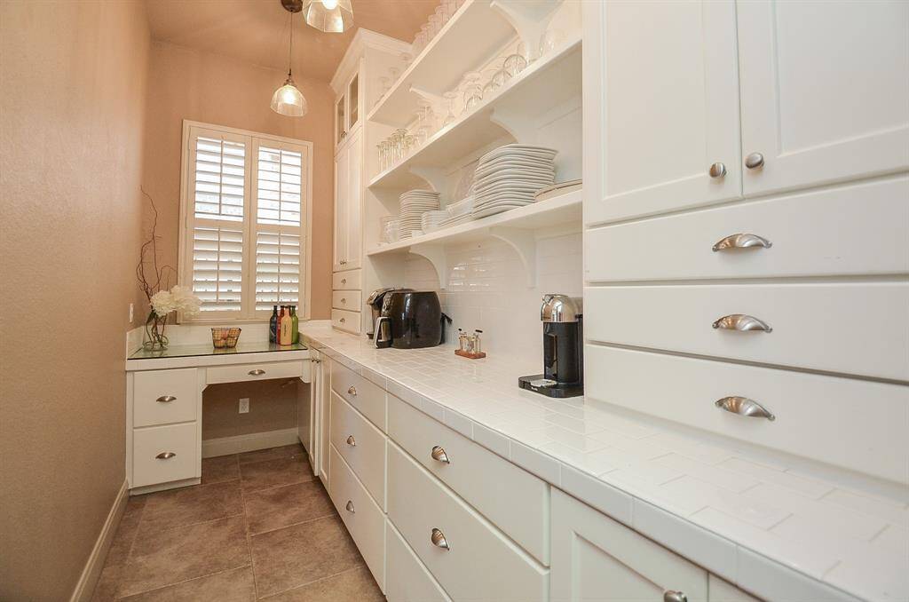 In the butler's pantry, you'll find ample cabinets and countertop space. Unseen in this view is an additional door behind you, leading to a food pantry.