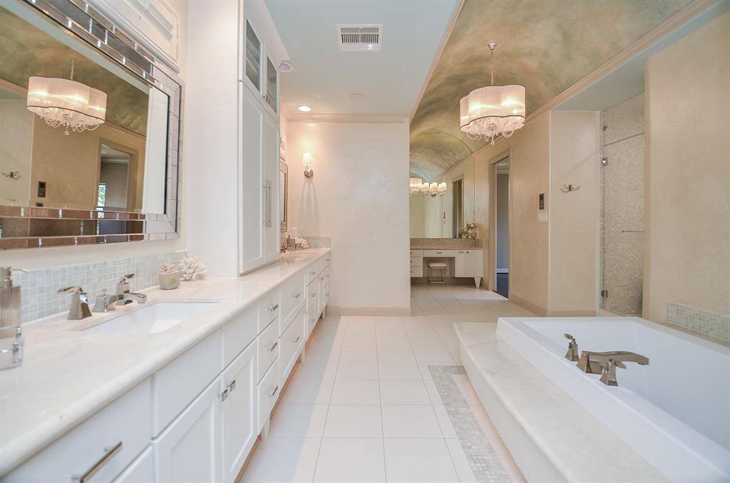 As you enter the primary bathroom, from the bedroom, you'll notice the designated makeup area. Adjacent to this space on the left (though not shown in the picture), there's a generously-sized primary closet equipped with abundant storage, complete with an island, as well as a washer and dryer. Towards the back of this closet, there's an entry leading to an extra room specifically designed for storage, whether it's for luggage, supplies, or seasonal decorations.