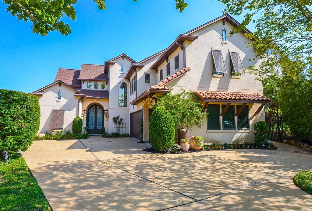 While the front of the home maintains an understated appearance, the true focal point is at the back, where the stunning view of the lake takes center stage. A circular drive with additional parking access is available outside the three-car garage.