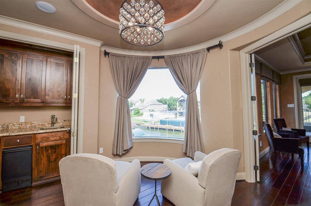 Adjacent to the primary suite, you'll discover a cozy sitting area and a well-equipped bar complete with a refrigerator and ice maker, all without the need to go downstairs. It's the perfect spot to brew your morning coffee and relax in the tranquil stillness before the sun graces the day.