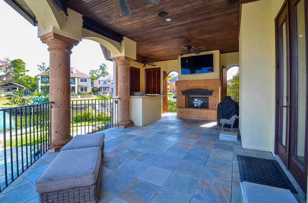 While the shutters are currently depicted as closed, when opened, they invite in the refreshing breeze and the airy ambiance that embodies lakeside living.The spacious outdoor kitchen can comfortably host outdoor sofas, chairs, stools, and still have ample room to spare. It's equipped with a barbecue pit, oven, sink, ice maker, and a cozy fireplace for your outdoor enjoyment.