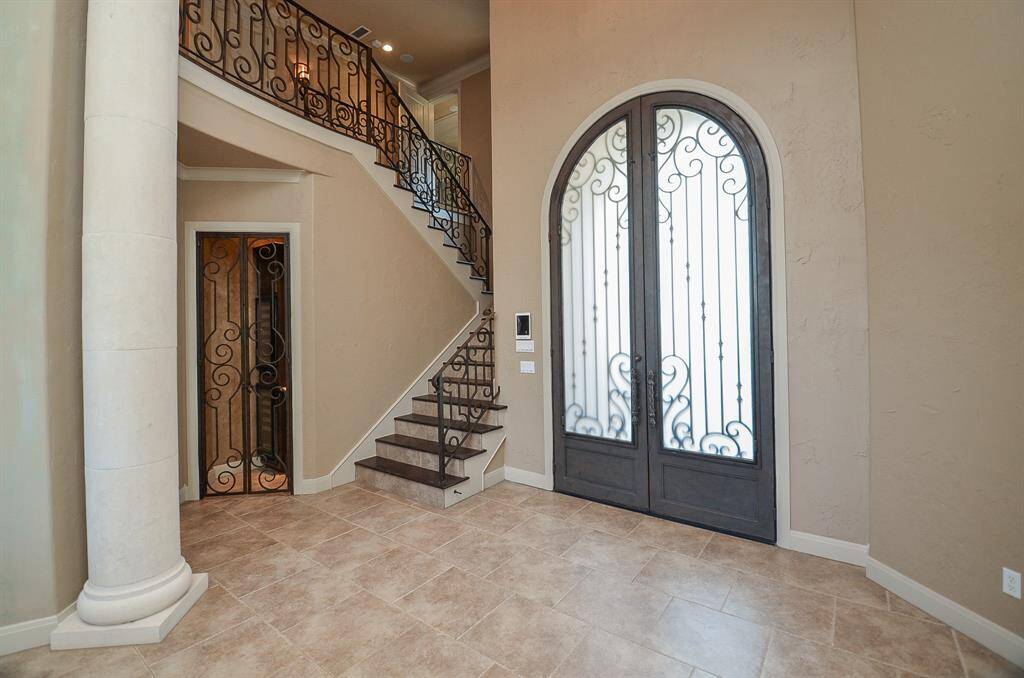 Observe how the door inserts seamlessly integrate with the stair railing, and how the door to the wine room harmonizes with both. For those intrigued by Feng Shui principles, the alignment of the stairway as it enters the room is particularly noteworthy.