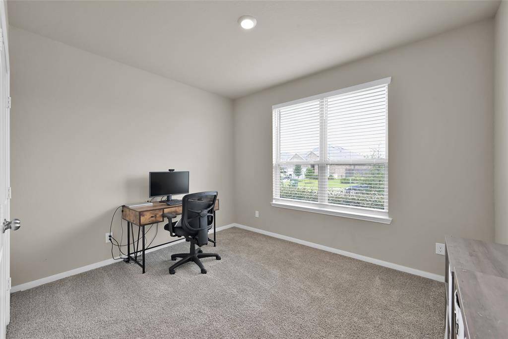 Cozy front bedroom with natural light currently being used as office space.